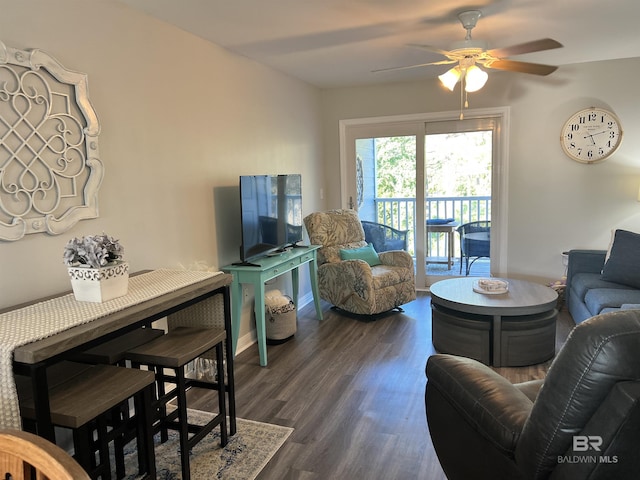 living area with a ceiling fan, baseboards, and dark wood-style flooring