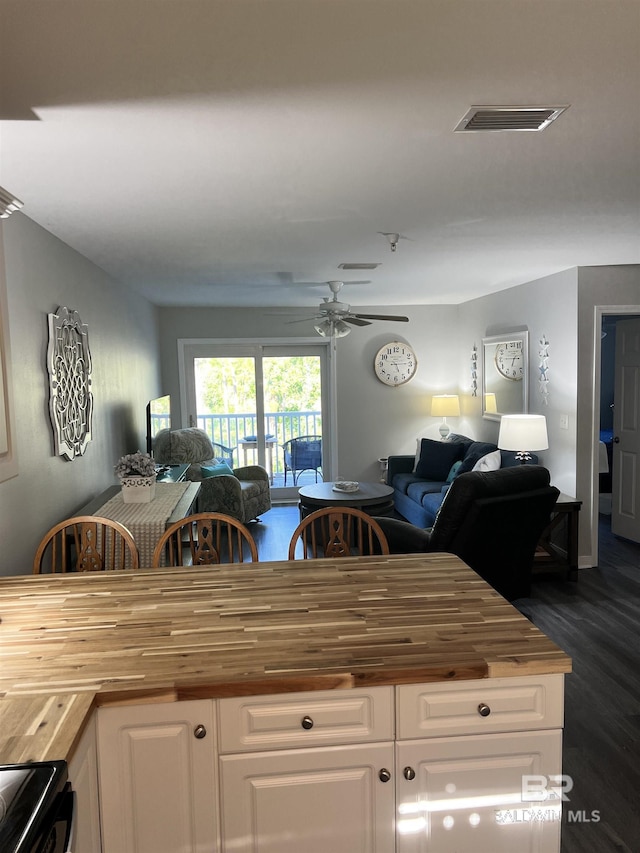 kitchen with open floor plan, wooden counters, electric range, and visible vents