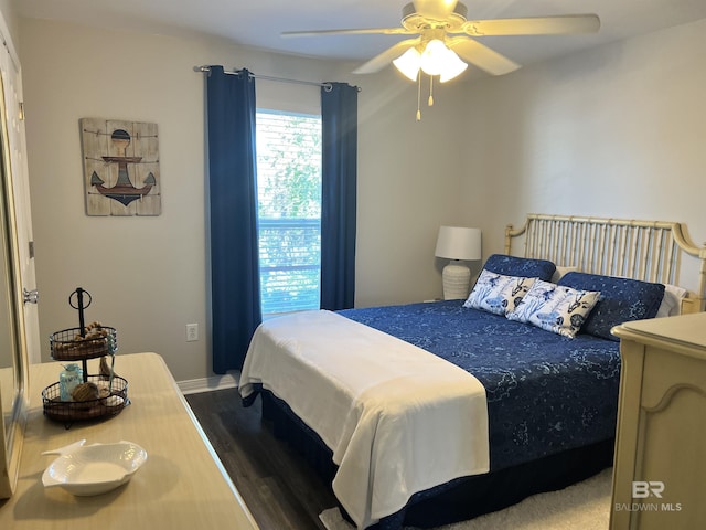 bedroom with baseboards, dark wood finished floors, and a ceiling fan