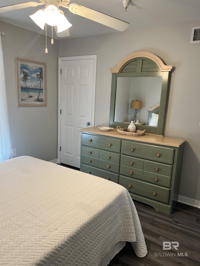 bedroom with dark wood-style floors, ceiling fan, visible vents, and baseboards