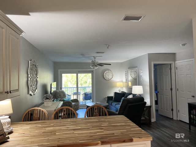 dining space with dark wood-style flooring, visible vents, and ceiling fan