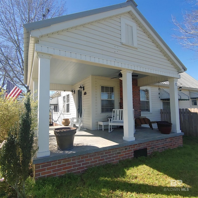 back of house featuring fence, a ceiling fan, and covered porch