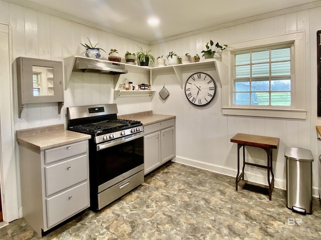 kitchen with stainless steel gas range oven, open shelves, under cabinet range hood, light countertops, and baseboards