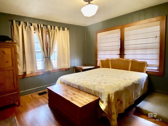 bedroom with visible vents, baseboards, and wood finished floors