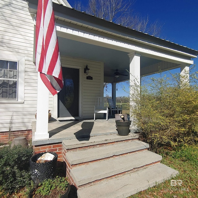 doorway to property featuring a porch and a ceiling fan