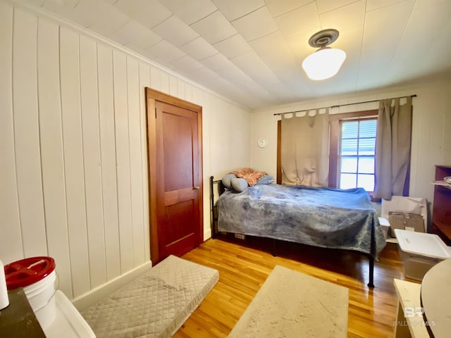 bedroom with crown molding and light wood-type flooring