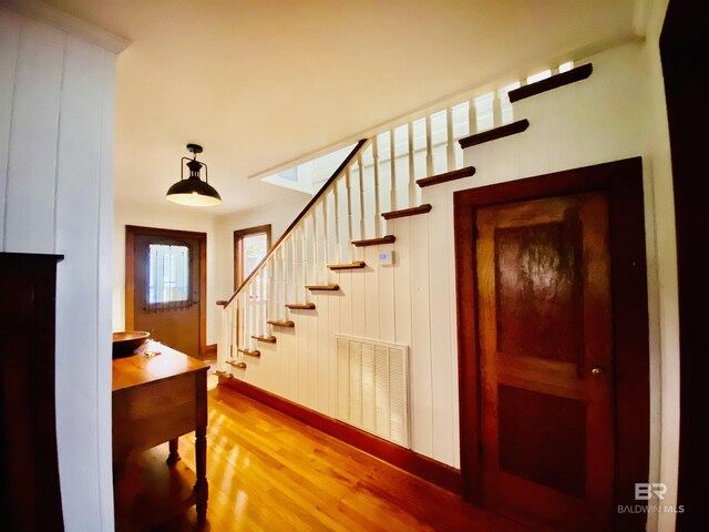 stairway featuring visible vents and wood finished floors