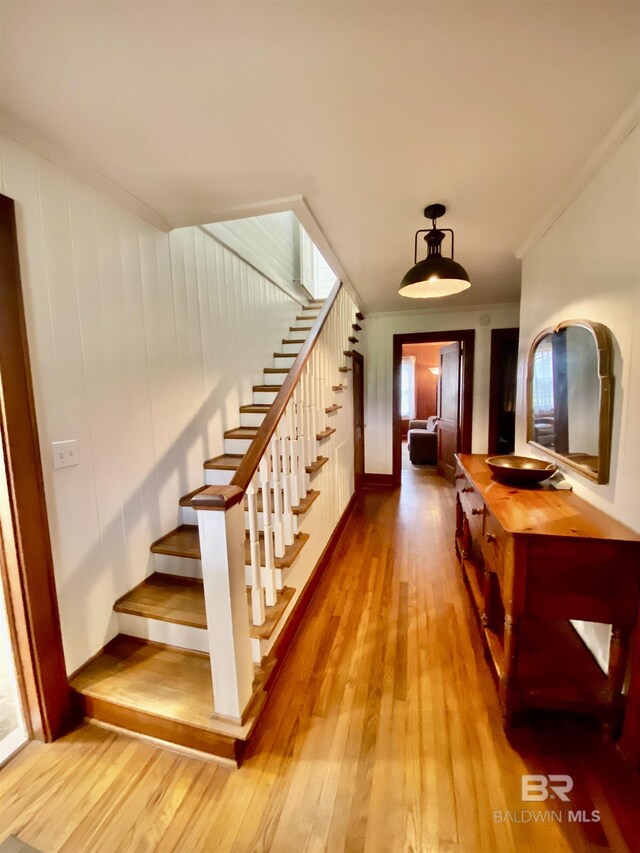 stairway featuring crown molding and wood finished floors