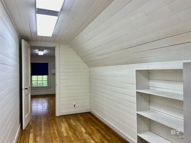 additional living space with wooden walls, wooden ceiling, lofted ceiling, and wood-type flooring