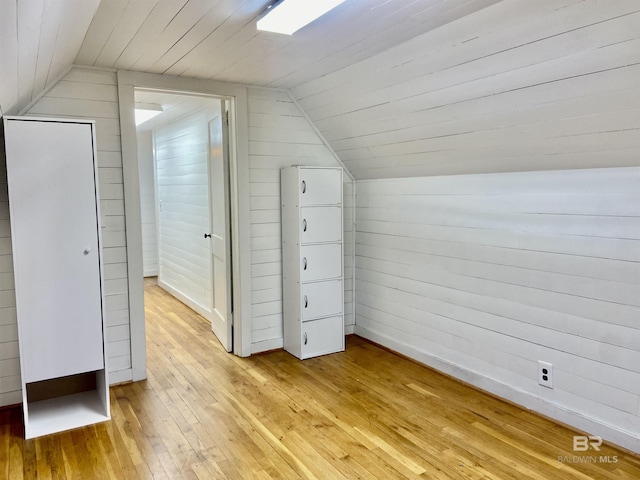 bonus room featuring wood walls, wooden ceiling, lofted ceiling, and light wood-style floors