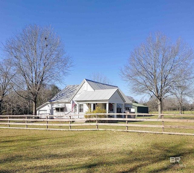 view of front facade featuring metal roof, fence private yard, and a front yard