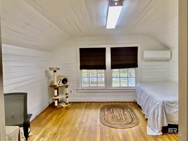 bedroom with an AC wall unit, wood ceiling, wood finished floors, and lofted ceiling