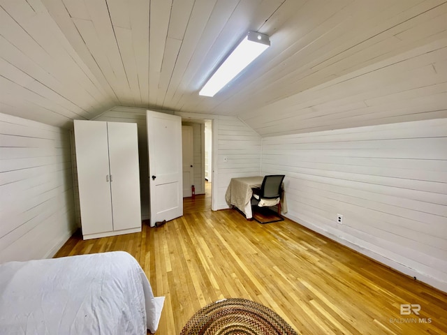 unfurnished bedroom featuring vaulted ceiling, light wood-style floors, and wooden ceiling