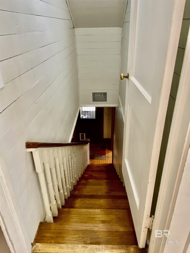 stairway featuring visible vents, wood walls, and wood finished floors