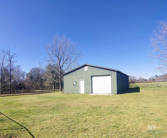 view of outbuilding featuring a rural view, an outbuilding, and fence