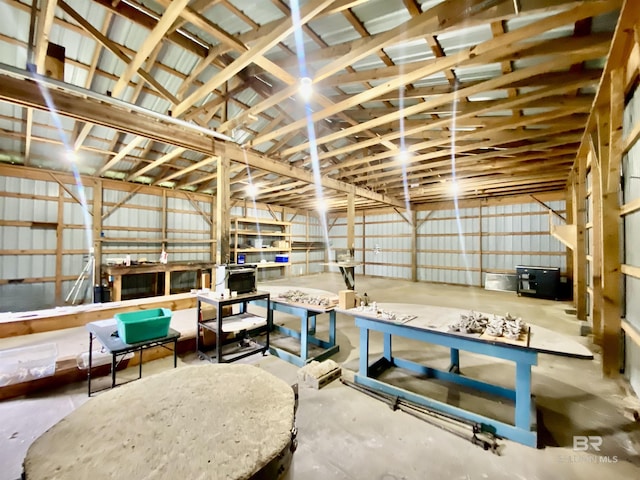 miscellaneous room featuring lofted ceiling and metal wall