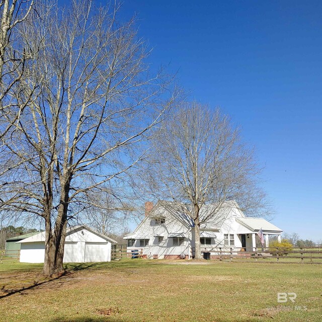 view of front facade with an outbuilding, a chimney, and a front yard