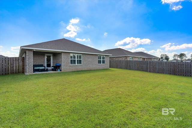 back of house featuring a yard and a patio area