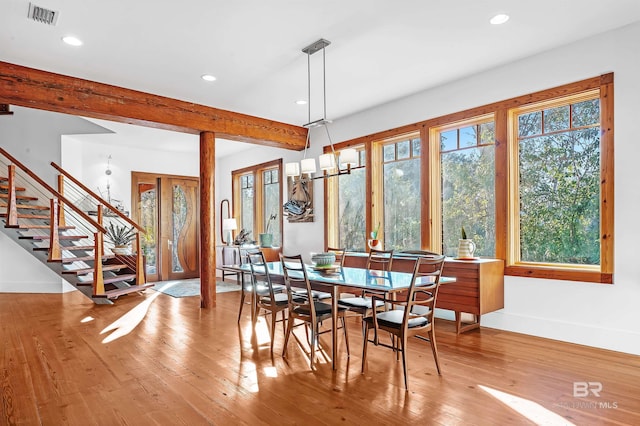 dining area with baseboards, visible vents, stairway, hardwood / wood-style floors, and beam ceiling