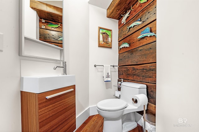 bathroom featuring toilet, baseboards, and vanity