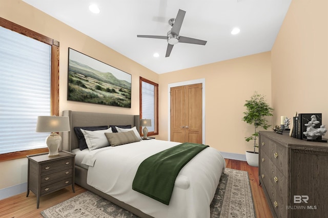 bedroom with recessed lighting, a closet, and wood finished floors