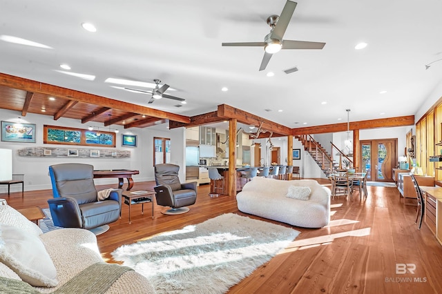 living area featuring light wood finished floors, beamed ceiling, and recessed lighting