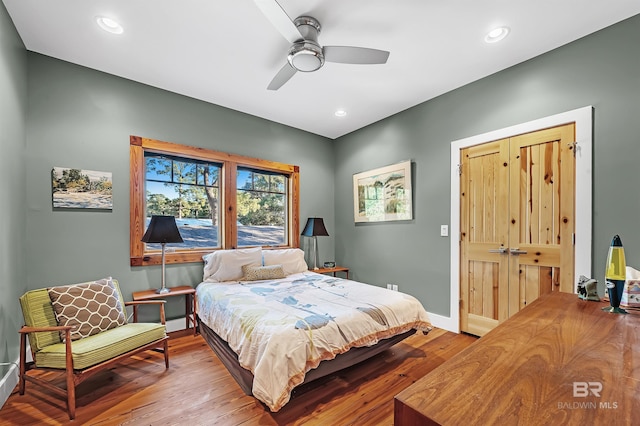 bedroom featuring a ceiling fan, baseboards, wood finished floors, and recessed lighting