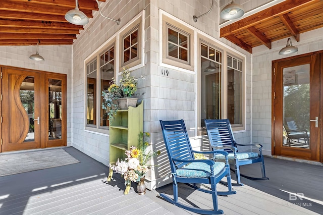 wooden terrace with french doors and a porch