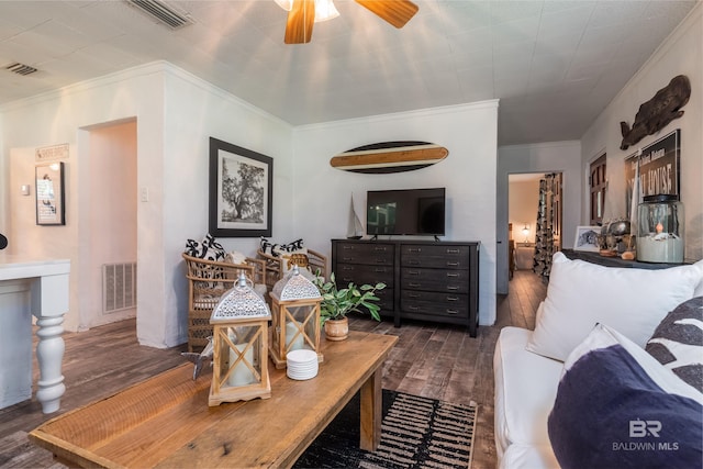 living room featuring dark wood-type flooring, crown molding, and ceiling fan