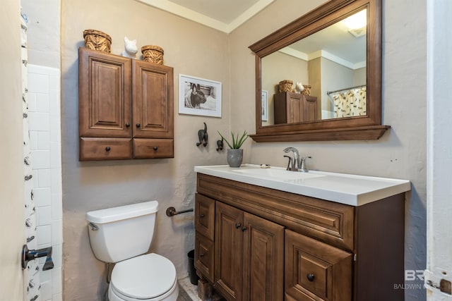 bathroom with toilet, vanity, and ornamental molding