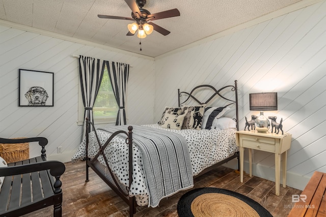 bedroom with hardwood / wood-style flooring, a textured ceiling, and ceiling fan