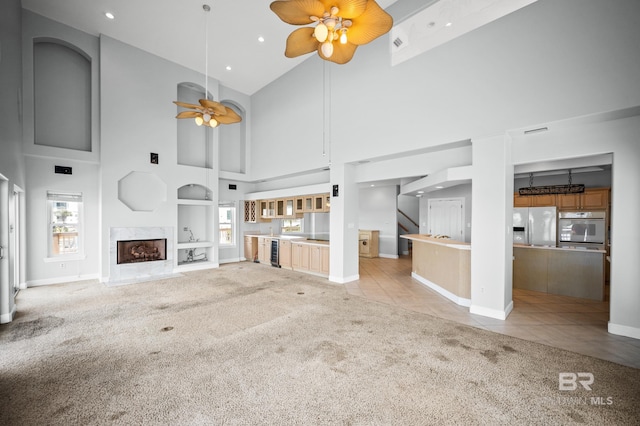 2024 W Beach Blvd, Gulf Shores, AL 36542 - unfurnished living room with ceiling fan, carpet floors, high vaulted ceiling, plenty of natural light, and stairway