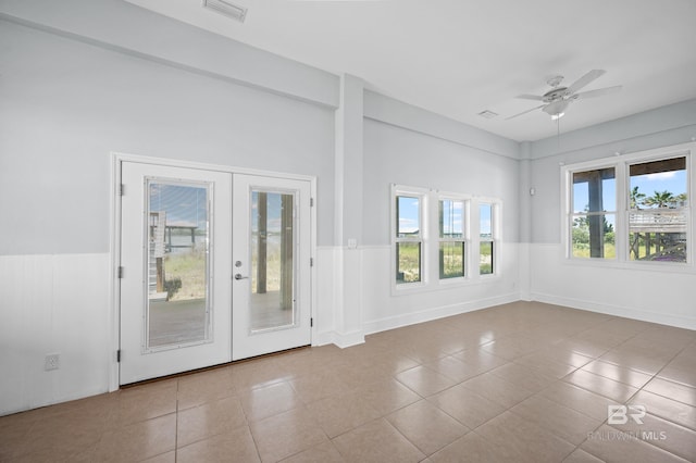 2024 W Beach Blvd, Gulf Shores, AL 36542 - tiled spare room featuring a wainscoted wall, french doors, and a ceiling fan