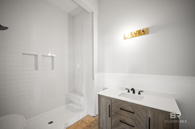 2024 W Beach Blvd, Gulf Shores, AL 36542 - bathroom featuring wainscoting, tiled shower, and vanity