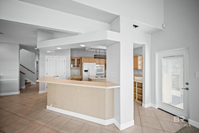 2024 W Beach Blvd, Gulf Shores, AL 36542 - kitchen with white appliances, light tile patterned floors, glass insert cabinets, light countertops, and recessed lighting