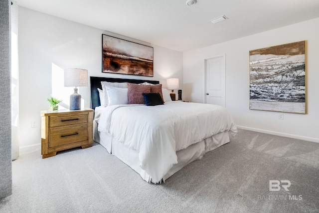 carpeted bedroom with visible vents and baseboards