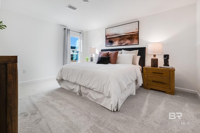 bedroom featuring visible vents, light carpet, and baseboards