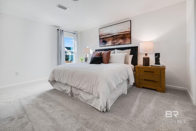 bedroom featuring visible vents, light carpet, and baseboards