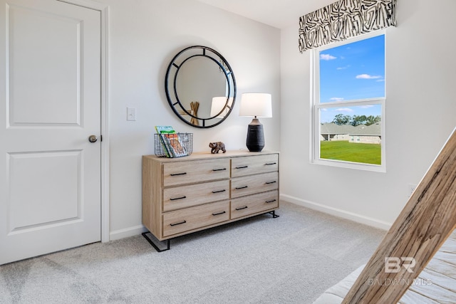 bedroom featuring light colored carpet and baseboards