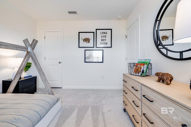 bedroom with baseboards, visible vents, and light colored carpet