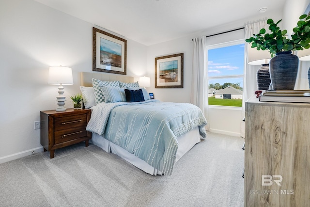 bedroom featuring light colored carpet and baseboards