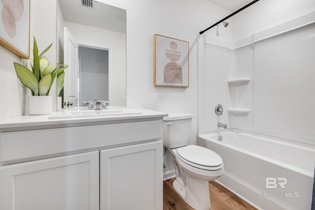 bathroom featuring visible vents, toilet, tub / shower combination, vanity, and wood finished floors