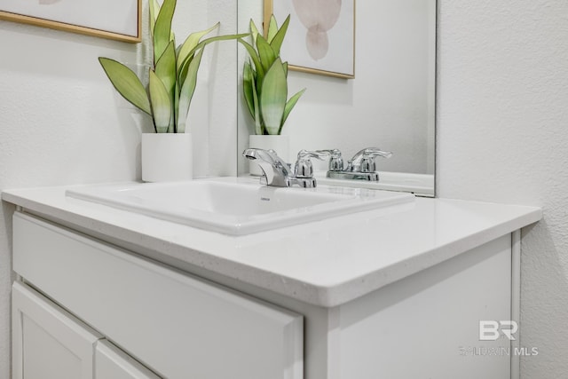 bathroom with a textured wall and vanity