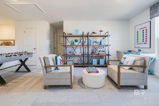 sitting room with carpet floors and attic access