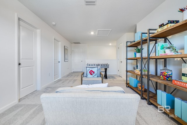 interior space with baseboards, attic access, visible vents, and light colored carpet