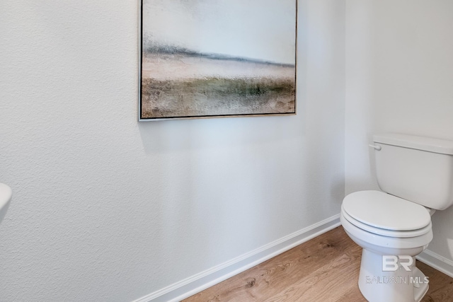 bathroom featuring wood finished floors, toilet, and baseboards