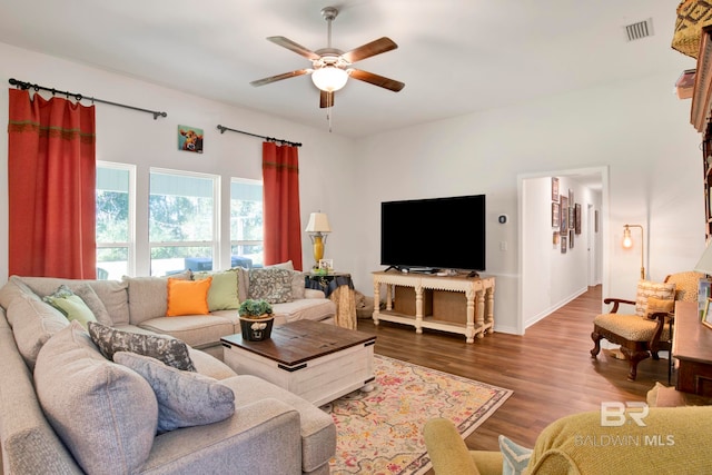 living room with dark wood-type flooring and ceiling fan