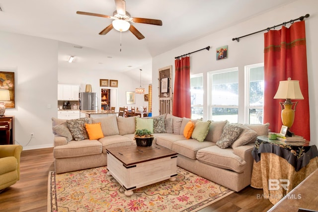 living room with ceiling fan, wood-type flooring, and lofted ceiling