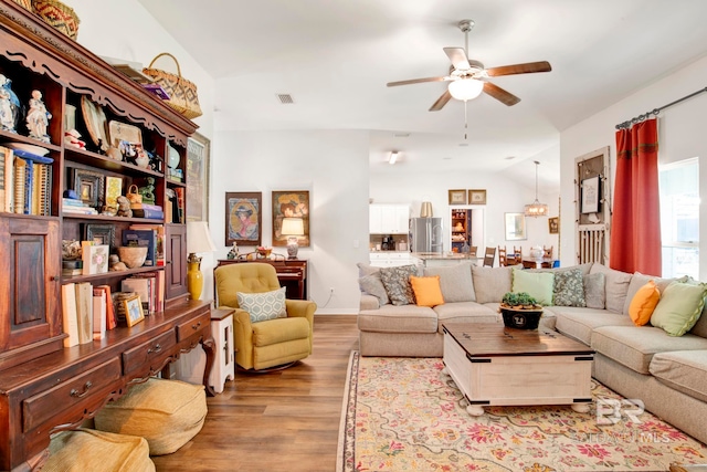 living room with light hardwood / wood-style floors, vaulted ceiling, and ceiling fan