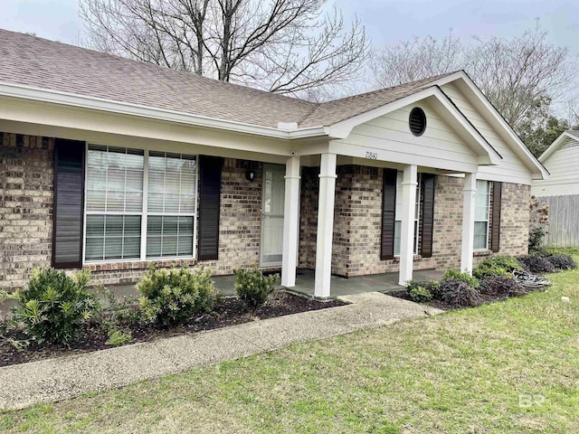 property entrance featuring a lawn and covered porch